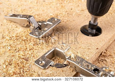 Installation Of Furniture Hinges In Chipboard. Small Carpentry Work In The Workshop.