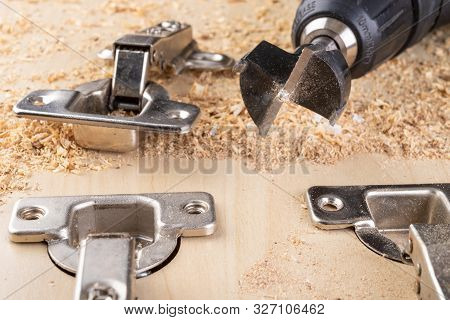Installation Of Furniture Hinges In Chipboard. Small Carpentry Work In The Workshop.