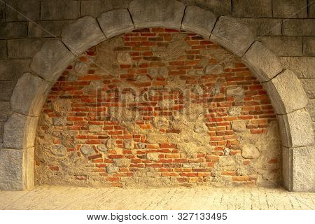 Wall Of Colorful Bricks Mixed With  Light Natural Stones. Mixed Bricks And Concrete Background. Arch