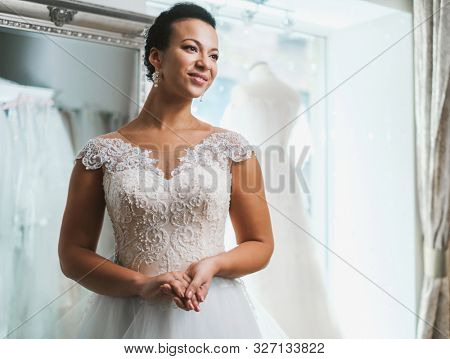 Beautifu bride choosing wedding dress in a wedding salon