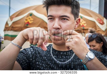 Ufa, Russia. July 12, 2019. Bashkir Turk Person Playing An Ethnic Lamellophone Instrument Known As J