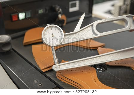 Woman Hands Use Leather Thickness Gauge On With A Natural Brown Leather. Preparing Of The Raw Materi