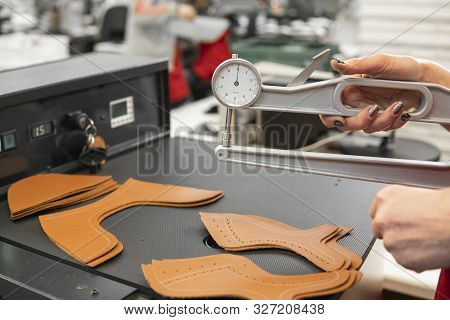 Woman Hands Use Leather Thickness Gauge On With A Natural Brown Leather. Preparing Of The Raw Materi