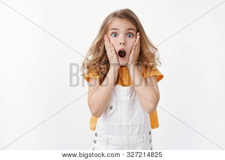 Scared And Shocked Caucasian Blond Little Girl Gasping, Grab Face Amazed, Stare Camera Astonished, D