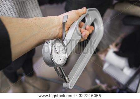 Mens Hands Use Leather Thickness Gauge On With A Natural Brown Leather. Preparing Of The Raw Materia