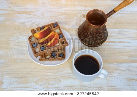 Chocolate Belgian Waffles With Fruits, Cup Of Coffee And Cezve On White Wooden Background. Delicious
