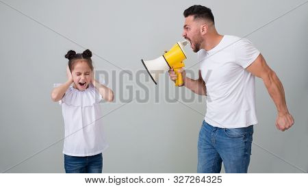 Domestic Tyranny. Scared Abused Girl Closing Her Ears, Hiding From Dad Who Screaming At His Daughter