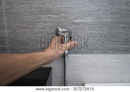 Using Of Bidet Shower In Bathroom With A Bidet Or Toiler. Bidet Shower In Male Hand For Using It In 