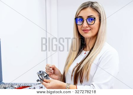 Female Ophalmologist Holds Corrective Glasses. Doctor In Spectacles. Opthalmology Test Box. The Univ