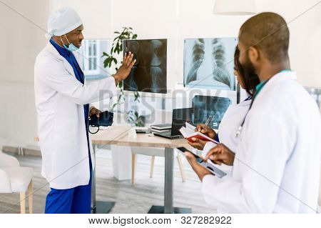 Healthcare, Medical: Group Of African Doctors Discuss And Looking X-ray In A Clinic Or Hospital. Afr