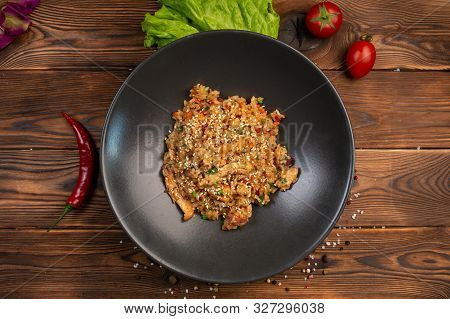 Tori Tyahan Fried Japanese Rice With Vegetables And Chicken In Soy Sauce In A Black Plate On A Woode
