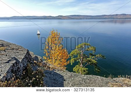 Sailing Boat On The Calm Lake Turgoyak, View From The Rocky Shore In Autumn, Southern Urals