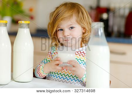 Adorable Toddler Girl Drinking Cow Milk For Breakfast. Cute Baby Daughter With Lots Of Bottles. Heal