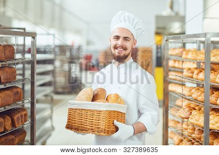 Bearded Baker Smiles Holding A Basket Of Bread At The Bakehouse