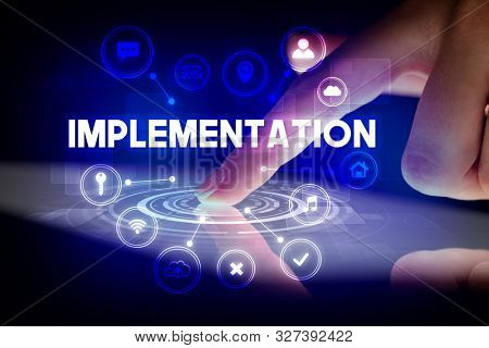Finger touching tablet with web technology icons and IMPLEMENTATION inscription, web technology concept