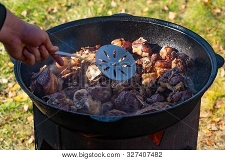 Cook Pieces Of Meat On Fire In A Large Cauldron. Boiled Meat In A Large Cauldron. The Horror Of A Ve