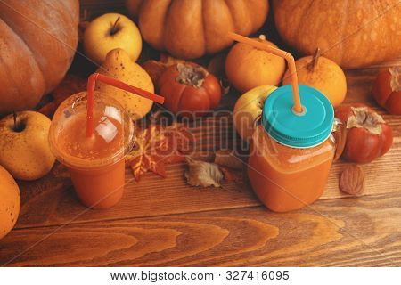 Pumpkins Juice In Bottles With Pumpkins. Two Glasses Cups Of Pumpkin Juice, Pumpkins And Fallen Ma. 