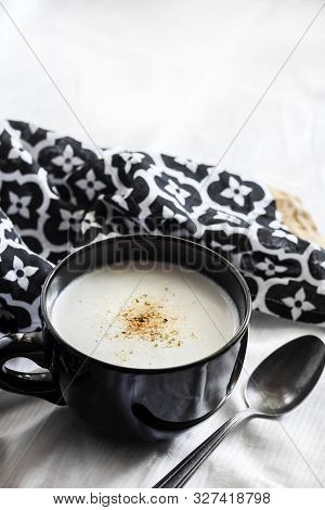 Cauliflower Soup (creme Du Barry) In Black Bowl On White Background With Black And White Cloth. Copy