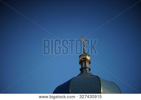 Dome Of The Orthodox Church And A Golden Cross Against A Blue Clear Sky