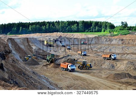 Wheel Front-end Loader Loads Sand Into A Dump Truck. Heavy Machinery In The Mining Quarry, Excavator