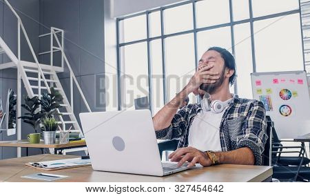 Creative Designer Yawn While Working Hard And Boring With Laptop At Modern Office.workplace Lifesyle