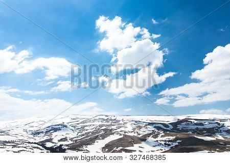 Lago Naki Spring Plateau With Snowy Hills, Blue Sky And Clouds