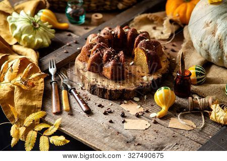 Tasty Homemade Baked Pumpkin Bundt Cake With Chocolate On Top Stands On Wooden Board On Rustic Table