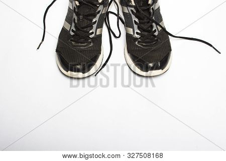 Old, Worn Sneakers With Holes On A White Background. Concept Of Running, Marathon, Ultramarathon, Lo