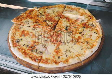 Hot Pizza Displayed For Sale Inside Display Case In Street Restaurant