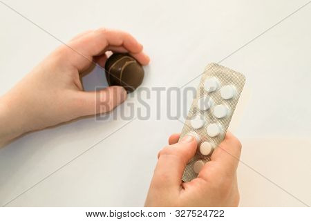 Concept Of The Dangers Of Sweets And Sugar. Child Holds In One Hand A Package Of Pills And Chocolate