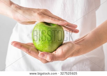 Young Caucasian Woman Girl In White Shirt Holding In Hands Raw Green Organic Apple. Stomach Gut Heal