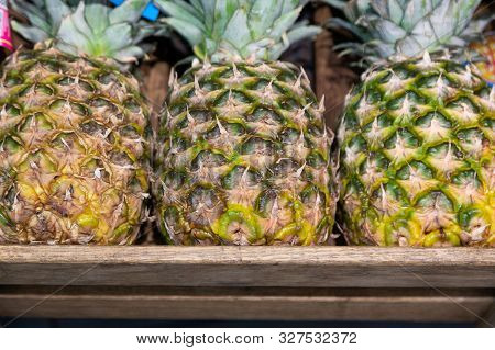 Wooden Lug Box With Exotic Pineapple On Supermarket Counter. Photo With Depth Of Field