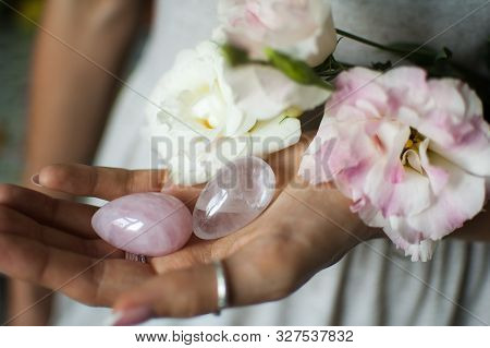 Female Hands Holding Two Yoni Eggs For Vumfit, Imbuilding Or Meditation Are Made From Pink Quartz An