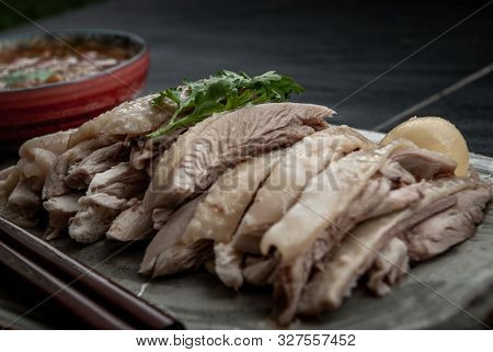 Close-up Of Asian Food Style Marinated Steamed Chicken (betong Chickken) And Sauce On Ceramic Plate.