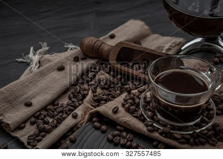 Coffee Style, Cup Of Coffee And Coffee Beans Roating With Old Wooden Scoop And Coffee Beans Around O