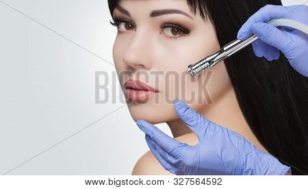 There Is A Woman, Who Is Making The Procedure Microdermabrasion Of The Facial Skin In A Beauty Salon