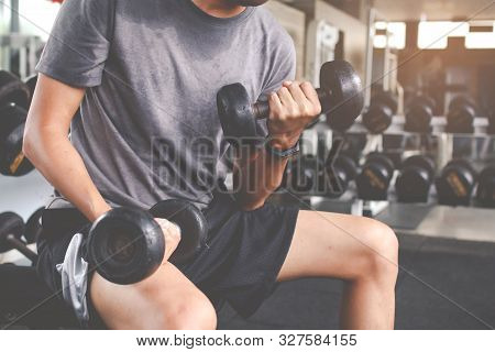 Closeup Of A Thin Man Doing Exercises With Dumbbell. Fitness Muscular Body. Fitness Concept