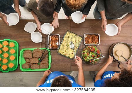 Volunteers Serving Food To Poor People Indoors, Top View