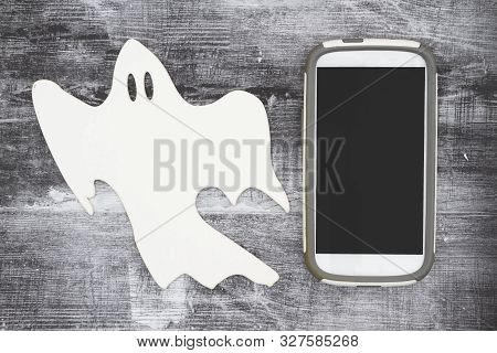 Ghosting Someone Online Message With A White Ghost And Cell Phone On Weathered Black Grunge Wood