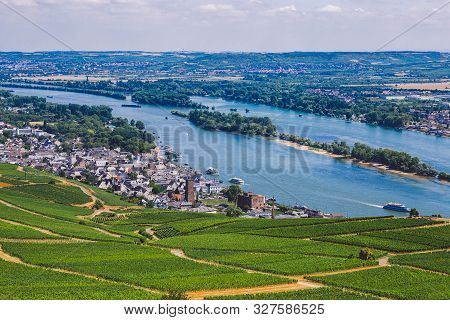 Panorama Of The Middle Rhine River Valley With Beautiful Vineyards Sloping Down To A Distant Medieva
