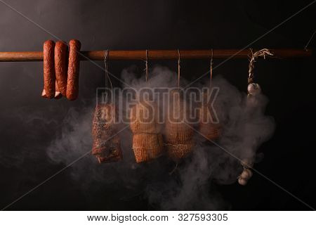 Traditional Smokehouse. Sausages, Hams And Bacon Surrounded By Smoke In A Smokehouse.