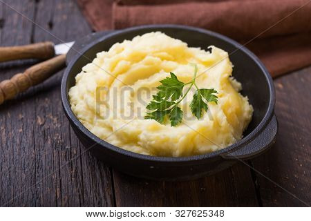 Potato. Mashed Potatoes Or Boiled Puree With Parsley  In Cast Iron Pot On Dark Wooden Rustic Backgro
