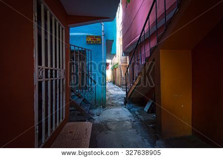 Santo Domingo, Dominican Republic; April 13, 2014: Narrow Hallway Between Multi-storey Apartments Wi
