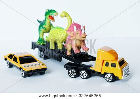 A Large Truck And A Car Transport Dinosaurs To A Nature Reserve, Farm Or Meat Processing Plant. Carg