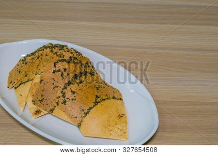 Closeup Of Crispy Traditional Korean Rice And Seaweed Cookies On White Serving Dish.