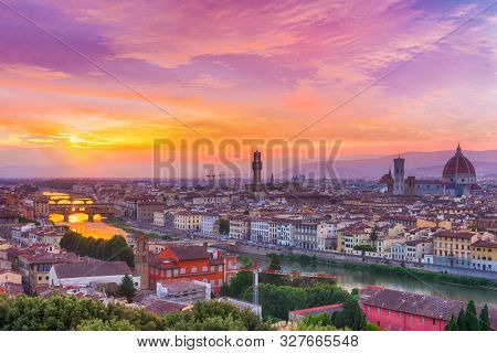 Vivid sunset over river Arno in Florence seen from Michelangelo square. In the picture could be seen Cathedral Santa Maria del Fiore, city hall Palazzo Vecchio and famous bridge Ponte Vecchio 
