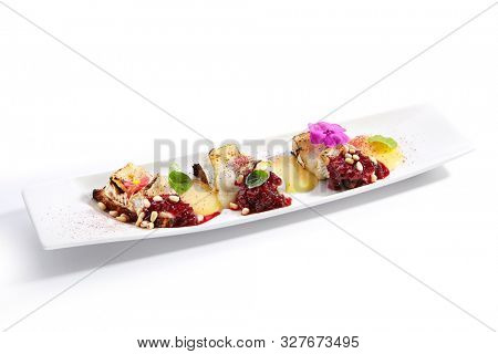 Beetroot carpaccio with stracciatella cheese closeup. Vegetarian dish with pear mousse and pine nut. Italian gourmet meal isolated on white background. Served and plated delicious  appetizer 