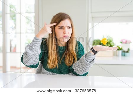 Young beautiful plus size woman wearing casual striped sweater confused and annoyed with open palm showing copy space and pointing finger to forehead. Think about it.