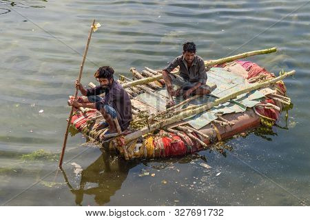 Udaipur, India - February 17, 2019: Indian Men Fishing On Raft On Swaroop Sagar Lake In Udaipur. Raj