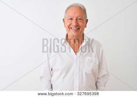 Senior grey-haired man wearing elegant shirt standing over isolated white background with a happy and cool smile on face. Lucky person.